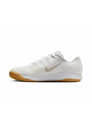 Witte lage Nike sportschoen met gestructureerde stof, beige swoosh-logo, witte veters en gum rubberen zool.
