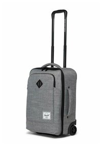 Valise à main souple grise avec poignée télescopique noire, poche avant, poignée latérale et roulettes pour un transport facile.