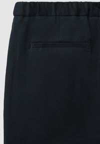 Pantalon noir avec une texture tissée lisse, doté d'une taille élastique et d'une poche arrière unique pour le rangement.