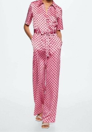 Vaaleanpunainen satiinihaalari, jossa on lyhyet hihat, mustia pilkkuja, solmittava vyötärö ja leveät lahkeet. Sileä pinta ja rento tyylinen yksityiskohdat.