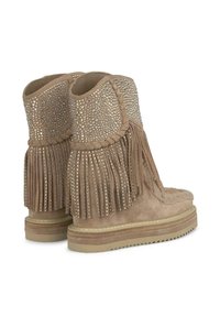 Stivaletti alla caviglia in suede beige con accenti di borchie, dettagli frangi e una suola texturizzata per una migliore aderenza. Progettati con punta tonda.