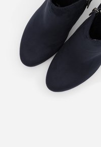 Pair of dark navy ankle boots with rounded toes on a white background, seen from above.