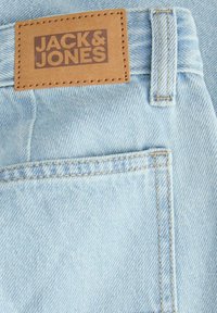 Ανοιχτό μπλε τζιν από τζιν υλικό με καφέ δερμάτινη ετικέτα που φέρει το ανάγλυφο "JACK & JONES". Περιλαμβάνει πίσω τσέπη και ενισχυμένη ραφή.
