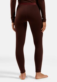 Burgundy leggings with a smooth texture, high waistband, and fitted design, featuring ankle cuffs and no visible patterns or hardware.