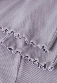 Tissu côtelé lavande avec bords froncés. Présente de fines lignes verticales et une texture douce, idéal pour une tenue décontractée.