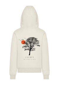 Beige hoodie featuring a large black tree graphic, an orange sun, and birds in flight. Text below reads "ESCAPE AND DISCOVER THE WORLD."