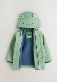 Grön vattentät jacka med en groddesign på huvan, med stora ögon och ett leende. Har dragkedja och innerfoder i marinblått.