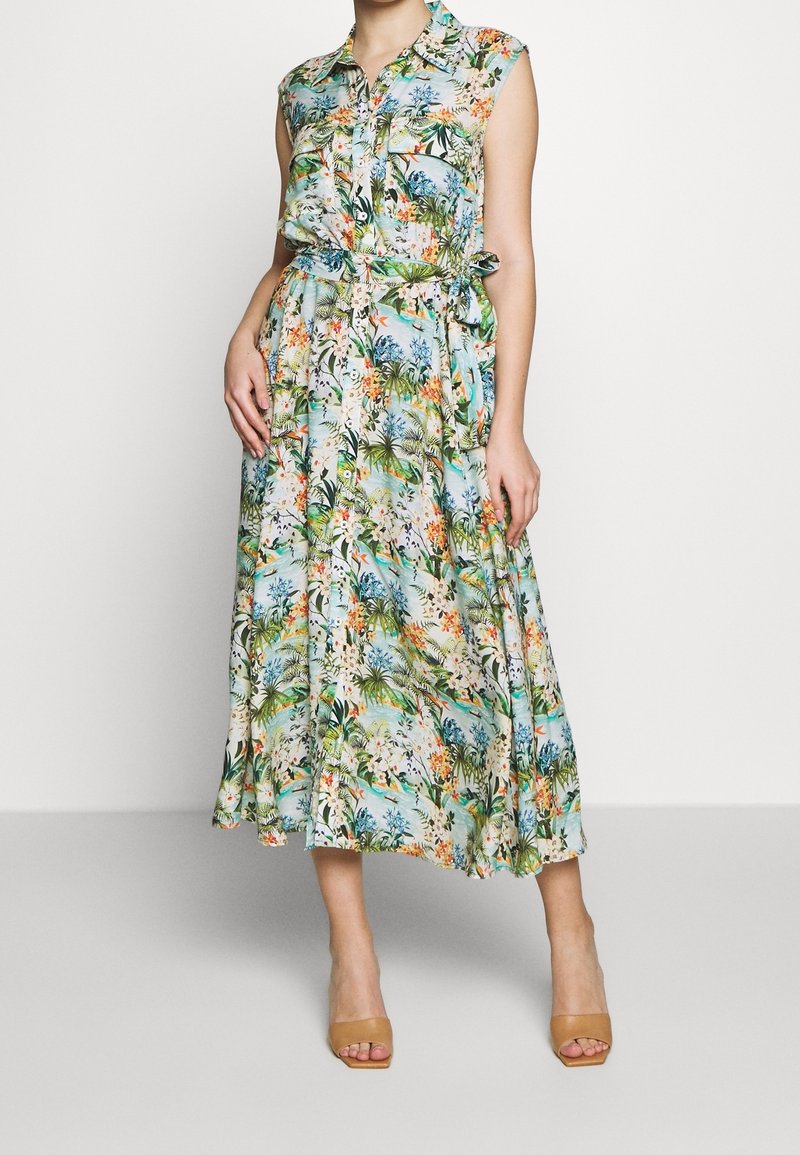 Blommig midiklänning med knäppkrage, korta ärmar, åtsittande midja och en svävande kjol. Materialet har ett livligt tropiskt mönster.