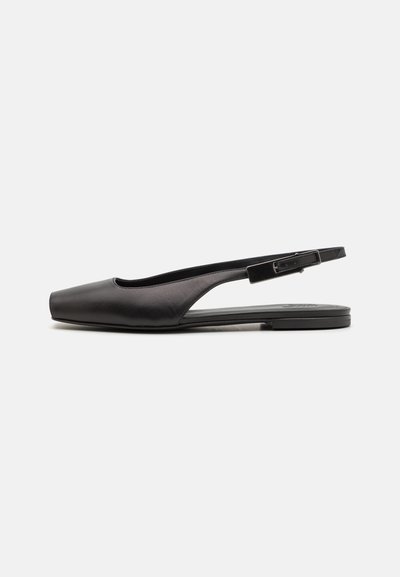 Svart läderslingback-sko med spetsig tå, platt sula och ett smalt justerbart rem. Slät textur och minimalistisk design.