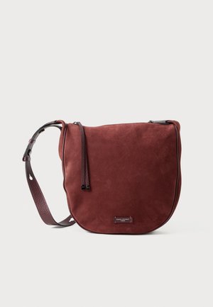 Bolso bandolera de ante rojo con forma curva, superficie texturizada y correa de cuero desmontable y ajustable con acentos de hardware metálico.