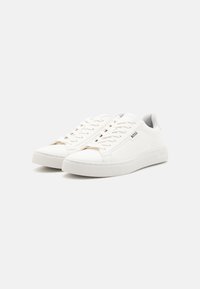 Baskets en cuir blanc avec un profil bas, un bout rond, des lacets ton sur ton et une semelle extérieure texturée. Le logo "BOSS" est affiché sur le côté.