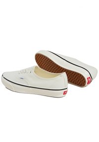 Weiße Leinensneaker mit runder Zehenpartie, schwarzen Gummistreifen und strukturiertem Gummisohle. Verfügt über ein Schnürdesign und rote Logoakzente.