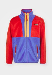 Chaqueta de forro polar con paneles rojos y azules, detalles de cremallera amarillos, cuello alto y bolsillos con cremallera. Textura suave, diseño informal.