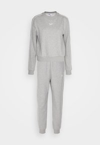 Ensemble de survêtement Reebok gris clair comprenant un sweat-shirt à manches longues et un pantalon de jogging, avec des bordures blanches et un petit logo sur la poitrine et la cuisse.