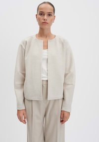 Beige wollen blend jas met een ronde halslijn, open voorkant en lange mouwen. Heeft een zachte textuur en een relaxte pasvorm.