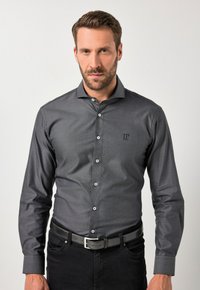 Camicia grigia a maniche lunghe con colletto abbottonato, caratterizzata da una sottile trama, logo ricamato sul petto e bottoni bianchi.