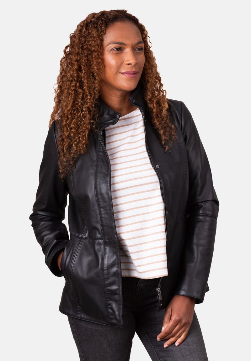 Black leather jacket with a snap collar, front pockets, and a fitted design, worn over a white and beige striped shirt.