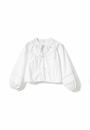 Biała krótka bluzka z okrągłym dekoltem, bufkami na rękawach i wiązaniem z przodu. Posiada delikatną koronkową lamówkę wzdłuż dekoltu i mankietów rękawów.
