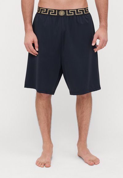 Marineblauwe shorts met een gouden patroon op de tailleband, voorzien van een leeuw-embleem. Gemaakt van een gladde stof, hebben ze een relaxte pasvorm en een knielange ontwerp.
