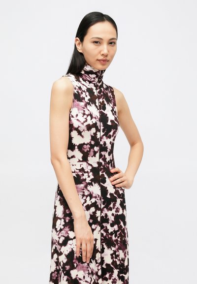 Αμάνικο φόρεμα με floral σχέδιο και ψηλό γιακά, με μαύρο φόντο και λευκά και μωβ λουλουδένια μοτίβα, υφή υφάσματος και φερμουάρ μπροστά.