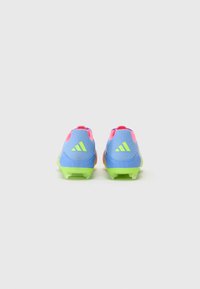 Blue and pink athletic cleats with a mesh upper, green rubber outsole, and three white stripes logo on the heel; features molded studs.