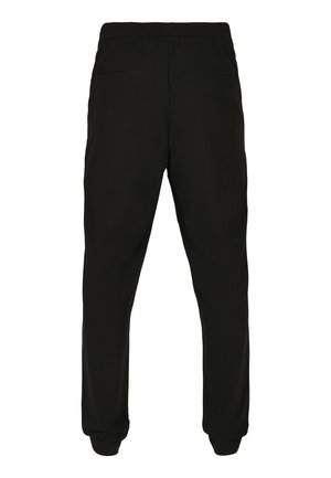 Zwarte, elastische broeken met een tailleband en zijzakken, en elastische boorden. Gladde stof met minimale textuur, ontworpen voor een ontspannen pasvorm.