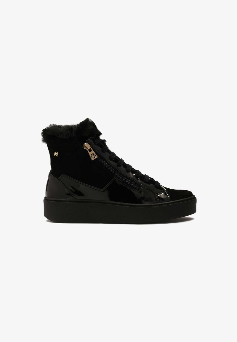 Stivale alla caviglia nero con esterno in pelle verniciata lucida e suede, dotato di un bordo in pelliccia, accessori in oro e una suola nera spessa.