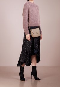 Vaaleanpunaista, pörröistä villapaitaa; mustat hameet, joissa on epäsymmetrinen helma ja valkoinen kukkaprintti; vaaleanbeige olkapussukka; mustat rypytetyt korkokengät.