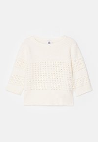 Pull blanc en maille avec une coupe ample, un col rond et des manches trois-quarts présentant des motifs texturés et un ourlet côtelé.