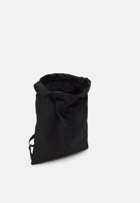 Borsa tote nera in morbido tessuto con top arricciato, manici robusti e un design semplice e privo di ornamenti per un'attrazione minimalista.