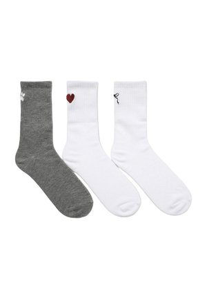 Tre paia di calzini da uomo: uno grigio con una stampa a forma di zampa bianca, due bianchi con un cuore rosso e un fiocco nero. Misura in misto cotone, con texture a coste.