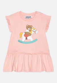 Vaaleanpunainen puuvillamekko, jossa on rypytetty hihansuut, kerä�äntynyt hame ja sarjakuvakarhu keinuvassa hevosessa -kuvio. Brändilogo, Moschino, näkyvissä.