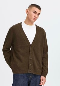 Dark brown cardigan with a V-neck, long sleeves, and six button closure. Made of soft fabric, features a relaxed fit and ribbed cuffs.
