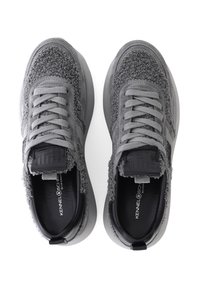 Graue Turnschuhe mit einer strukturierten Oberseite, die mit einem flauschigen Detail und einer glatten, flachen grauen Sohle versehen sind. Schnürdesign mit schwarzen Akzenten innen.