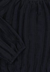 Marineblauwe textuurstof met verticale strepen en geplooide mouwen. Heeft delicate lintaccenten langs de naden.