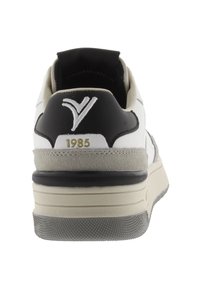 Sneaker bianco e nero con accentuazione in suede grigio, suola ammortizzata, design alto, caratterizzato da un logo e dettaglio "1985" sul tallone.