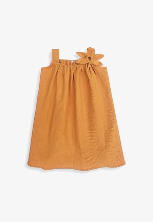 Ærmeløs orange tekstureret kjole med indsamlet halsudskæring og en stor stofblomst fastgjort til den ene skulderstrop.