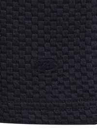 Telar de tejido navy con un patrón texturizado. Presenta un logotipo sutil en la esquina inferior, que resalta el diseño intrincado del tejido.