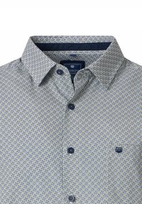 Hemd mit Knopfleiste aus leichtem Stoff in blau-weißem kreisförmigen Muster. Verfügt über einen klassischen Kragen und dunkelblaue Knöpfe. Kleines Logo auf der Brust.