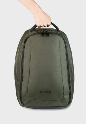 Grüner Nylon-Rucksack mit schlanker Form, ausgestattet mit einem schwarzen Reißverschluss, robustem Griff und dem "MUNICH"-Logo auf der Vorderseite.