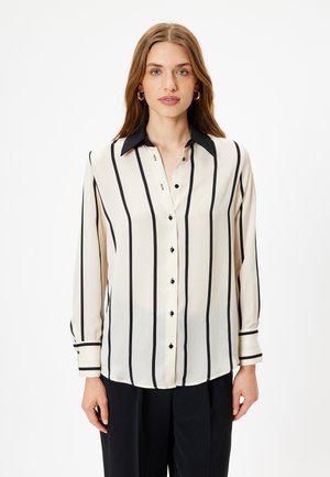Cream blouse with vertical black stripes, long sleeves, and a black collar. Features button front and wrist cuffs with matching black stripes.