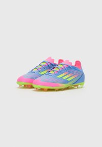 Soccer cleats in blue with pink accents and neon yellow details. Features a textured synthetic upper and multi-colored studded outsole.
