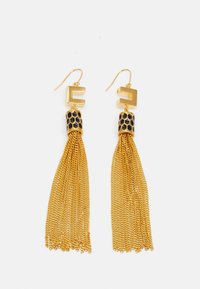 Brincos de ouro com uma forma geométrica na parte superior, um detalhe em favo de mel texturizado em preto e dourado, e longos fios de corrente fina de ouro.
