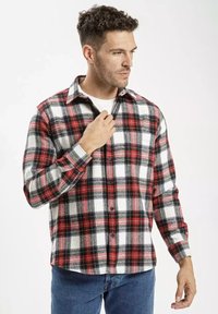 Czerwono-czarny i biały w kratkę flanelowy shirt z długimi rękawami, z przodu zapinany na guziki, z kołnierzykiem. Miękka struktura z wyraźnym wzorem w kratkę.