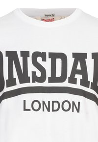 Fehér pamut póló fekete nyomattal, amelyen a "LONSDALE" ívben a "LONDON" felirat felett található. Normál szabású, kerek nyakkivágással; észlelhető textúrák vagy minták nélkül.