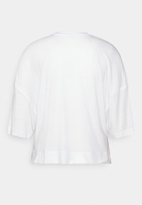 T-shirt bianco a maniche corte, vestibilità ampia, orlo arrotondato, realizzato in cotone morbido, design semplice, senza loghi o fantasie visibili.
