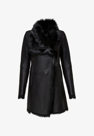 Chaqueta de cuero negro con un cuello de piel sintética, que cuenta con bolsillos con cremallera y un diseño elegante. Textura suave con detalles de piel.