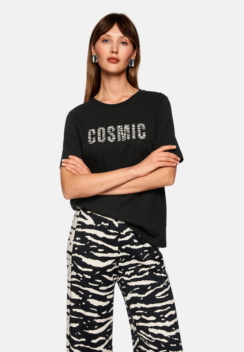 Black short-sleeve t-shirt with "COSMIC LOVE" in zebra print, paired with wide-leg pants featuring a black and cream tiger stripe pattern.