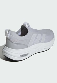 Ljusgrå sportskor med övre del i stickad textil, tre vita ränder, dragflik och texturerad sula med Cloudfoam dämpning.