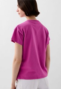 Korte mouwen t-shirt van felroze katoen, met een relaxte pasvorm, ronde hals en een klein detail aan de achterkant bij de kraag.